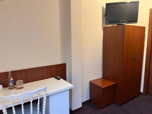 a room with a table and a tv on a cabinet at Dworek Dębicki in Dębica
