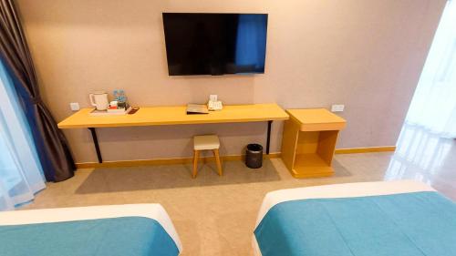 a room with a desk with a television on a wall at ARK HOTEL in Phnom Penh
