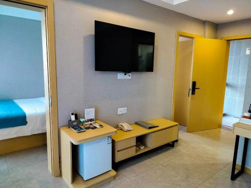 a room with a desk and a television on the wall at ARK HOTEL in Phnom Penh