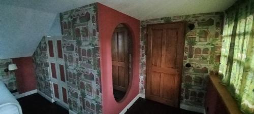 a room with a wooden door and a wall with a mirror at Villa Hortensia in Bagnères-de-Bigorre