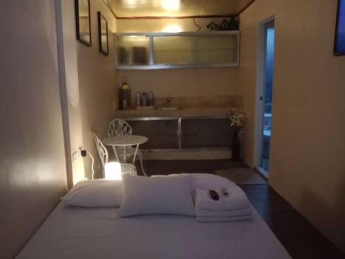 a white bed in a room with a bathroom at TerisitaPlace - LoveAtFirst in Taytay