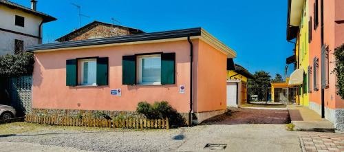 - un petit bâtiment avec des fenêtres vertes dans une rue dans l'établissement Incredibile Appartamento con doccia Idromassaggio, 