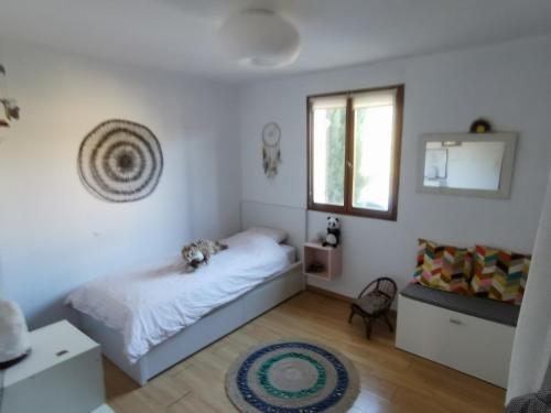 a small bedroom with a bed and a window at Villa La Ressourcerie a Saignon in Saignon