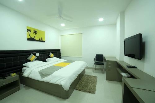 1 dormitorio con 1 cama y TV de pantalla plana en La Riviera Suites Madhapur en Hyderabad