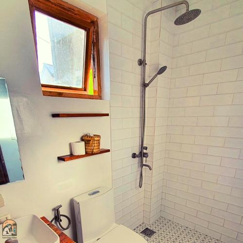 a bathroom with a shower with a toilet and a sink at Luna Tres Homestay Siargao in General Luna