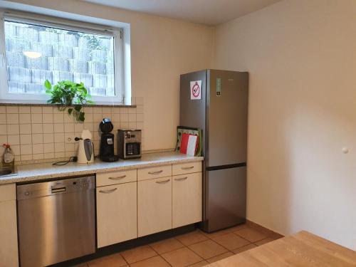 a kitchen with a stainless steel refrigerator and a window at Ferienwohnung Ela 1 in Andernach