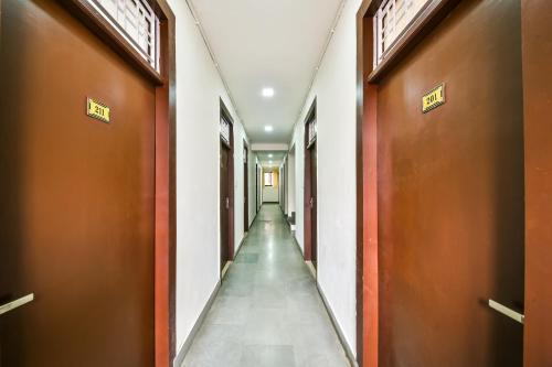 un couloir avec des portes brunes et un long couloir dans l'établissement OYO Hotel Tirupati Residency, à Kota