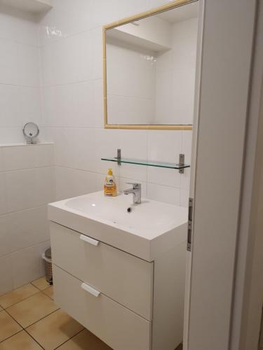 a white bathroom with a sink and a mirror at Ferienwohnung Ela 1 in Andernach