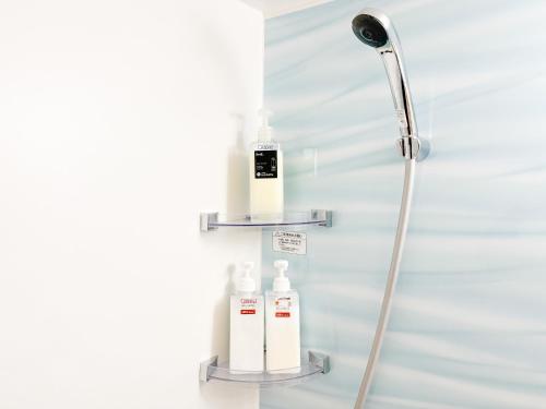 a shower with two bottles of soap on a wall at Apartment Hotel Side of Shinsaibashi Shopping street in Osaka