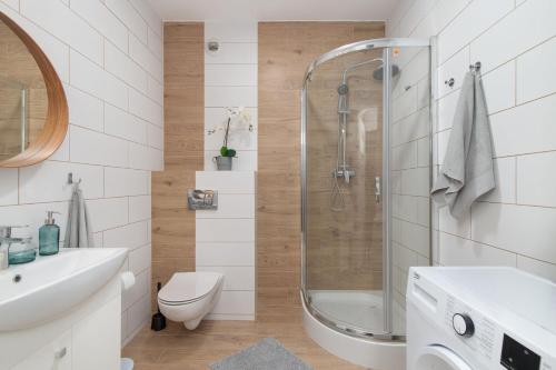 een badkamer met een douche, een toilet en een wastafel bij Sunny Terrace Point in Poznań