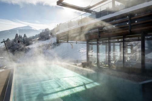 a swimming pool with steam coming out of it at Das.Goldberg in Bad Hofgastein