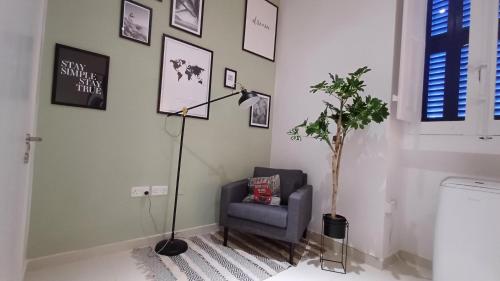 a living room with a chair and a lamp at Is- Sienja in Kalkara