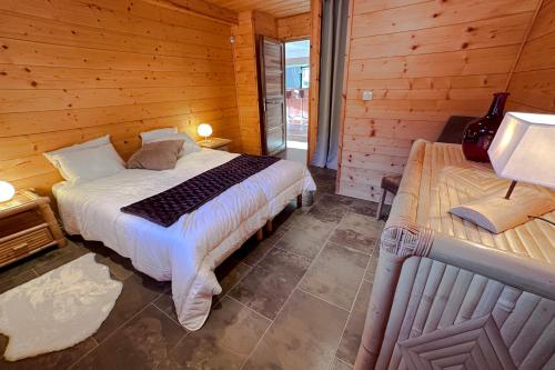 a bedroom with a bed in a wooden cabin at CHALET DE LA COULEE - Chalet de grand standing avec spa offrant une vue sur la vallée in Eyne