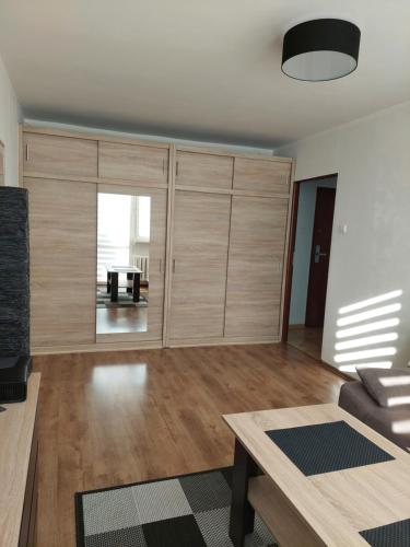 a living room with wooden cabinets and a table at Apartament 59 , ranczoturystyka Bielawa Sudety in Bielawa