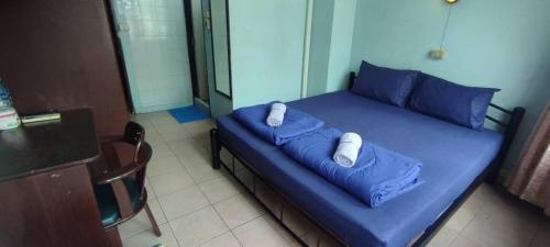 a blue bed with two pillows on it in a room at NAT 2 Guest House in Bangkok