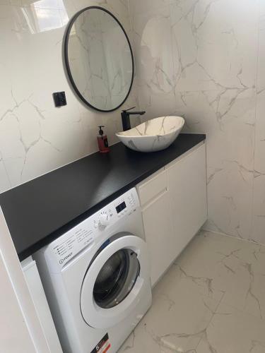 a bathroom with a washing machine and a mirror at Biebrzańska Przystań in Goniadz