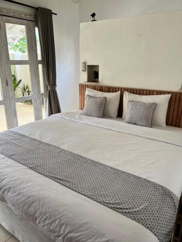 a large bed with white sheets and pillows at Villa Tom & Lucie Bingin Beach in Uluwatu