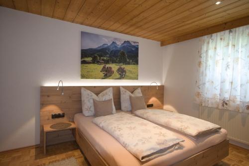 a bedroom with a bed with a painting on the wall at Ferienhaus Gapp in Elmen