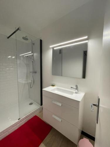 a white bathroom with a sink and a shower at Le Chamois in Chamrousse