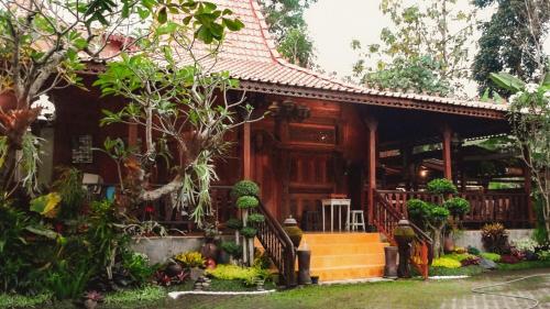 a house in a garden with trees and plants at Cokro Hinggil - Traditional View in Sleman