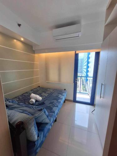 a bedroom with a bed with a stuffed animal on it at Sea Residences MOA-Eric Apartments in Manila
