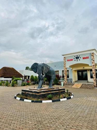a statue of a person is in front of a building at Kacoke Madit Hotel and Cultural Centre, Gulu in Gulu