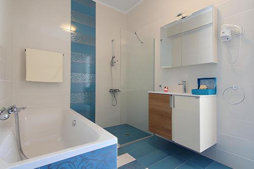 Baño blanco con bañera y lavamanos en Villa Iremia Des vacances waouw en toute sérénité! en Chaliotata