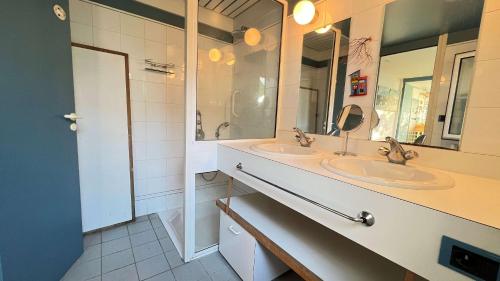 ein Badezimmer mit zwei Waschbecken und einem großen Spiegel in der Unterkunft Jolie maison avec jardin, piscine et parking in Sainte-Marie-de-Ré