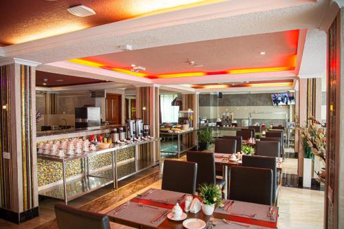 a restaurant with tables and chairs and a bar at Tiffany Diamond Hotels LTD - Makunganya in Dar es Salaam