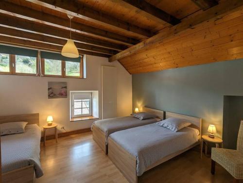 - une chambre avec 2 lits et 2 fenêtres dans l'établissement Le Gîte de la Perheux, à Wildersbach