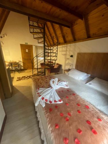 a bedroom with a bed with red flowers on it at VILLA ITÁLIA CHALÉ in Santo Antônio do Pinhal