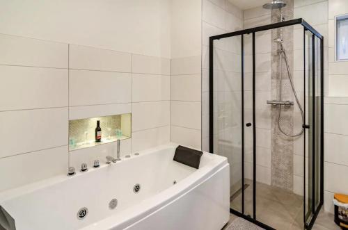 a white bathroom with a tub and a shower at Wellenrauschen - Whirlpool Badewanne - Terrasse - Ruhig gelegen in Wilhelmshaven