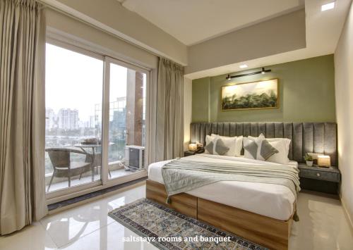 sypialnia z dużym łóżkiem i dużym oknem w obiekcie Saltstayz Premier Executive Serviced Apartment - Golf Course Extension Road w mieście Gurgaon