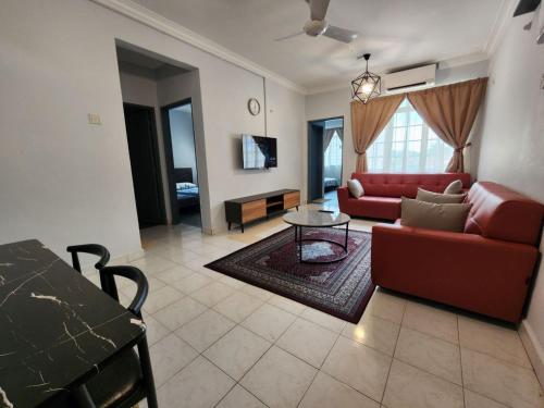 a living room with a red couch and a table at Thetamu Homestay مسلم Pesona in Jalan Baharu