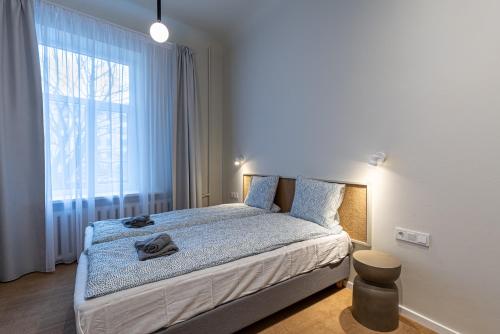 a bedroom with a bed and a large window at Dandelion Apartments Ģertrūdes in Rīga