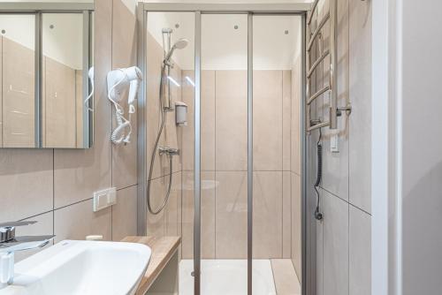 La salle de bains est pourvue d'une douche et d'un lavabo. dans l'établissement Dandelion Apartments Ģertrūdes, à Riga