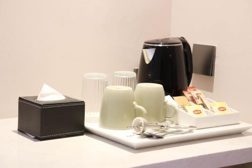 a counter with a coffee maker and a box on it at The Quarter Ratchathewi by UHG in Bangkok