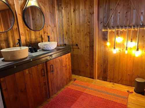ein Badezimmer mit Holzwänden, einem Waschbecken und einem Spiegel in der Unterkunft Quinta Aurora in Burgau