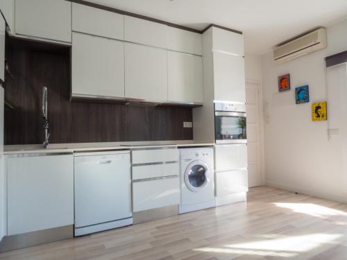 シッチェスにあるCasa Roma Sitges Penthouseのキッチン(白いキャビネット、洗濯機、乾燥機付)