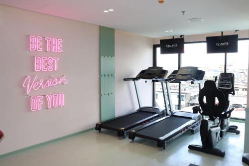 a gym with two exercise bikes and a wall with a sign at The Quarter Ratchathewi by UHG in Bangkok