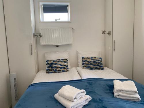 una piccola camera con due letti con asciugamani di De Zeekreeft a Katwijk aan Zee