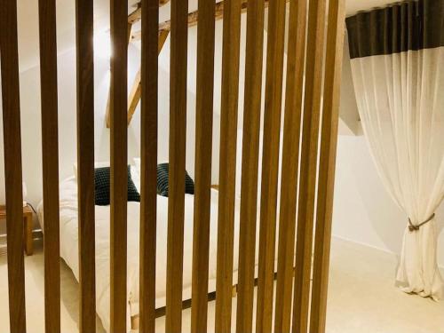 una culla in legno in una camera da letto con tende di Magnifique Loft rénové-Quartier Culturel - Bureau a Pau