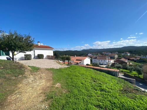 a house on top of a grassy hill at Cottage Abrunheiro Grande in Vila de Rei
