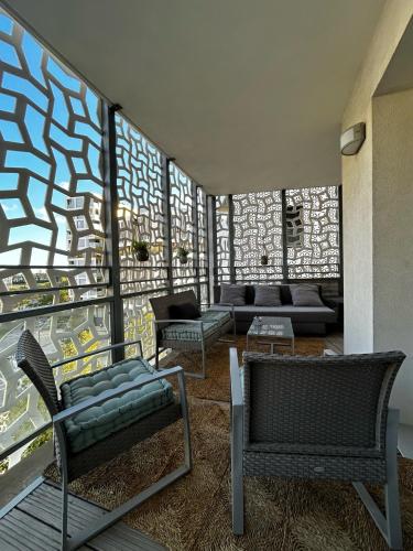 un salon avec un canapé et un mur de fenêtres dans l'établissement Appartement cosy - Port Marianne - Garage sous sol, à Montpellier