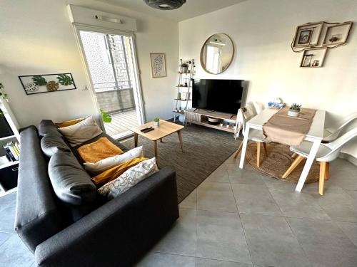 un salon avec un canapé et une table dans l'établissement Appartement cosy - Port Marianne - Garage sous sol, à Montpellier