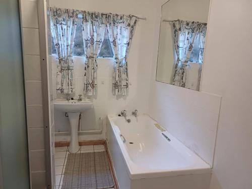 a white bathroom with a sink and a tub and a sinkessment at The Viewing Deck Accommodation in Clarens