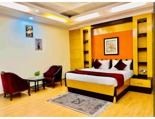 een hotelkamer met een bed en een tafel en stoelen bij Awadh Inn ,Lucknow in Lucknow