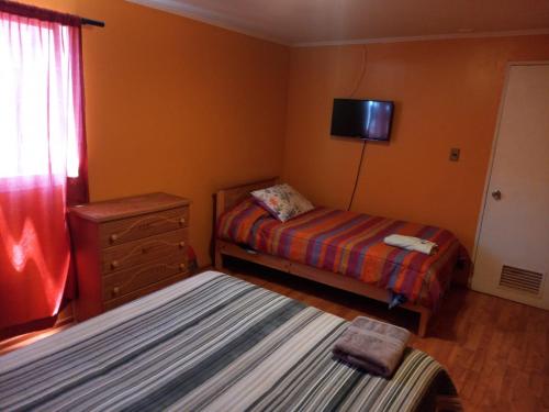 - une chambre avec 2 lits et une télévision murale dans l'établissement HOSTAL LA CASONA ALFREDO CAMPOS, à Ovalle