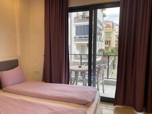 a bedroom with a bed and a view of a balcony at Rose 5 in Alanya