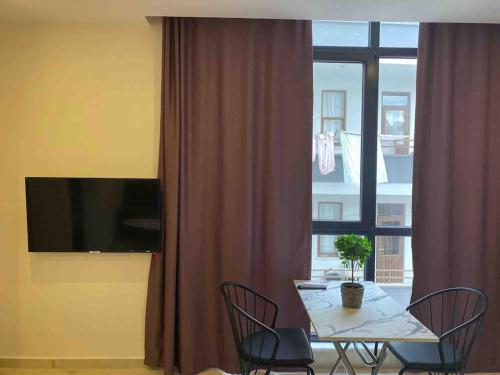 a dining room table with chairs and a large window at Rose 5 in Alanya